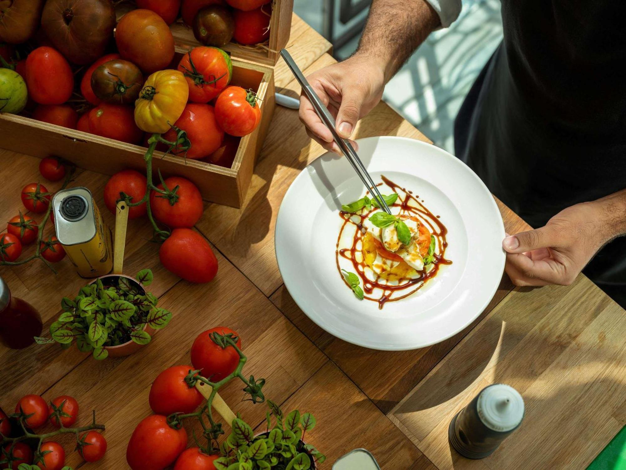 페어몬트 밥 알 바흐 호텔 아부다비 외부 사진 A chef finishing a plate of food